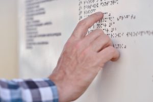 Man reading the Braille plate